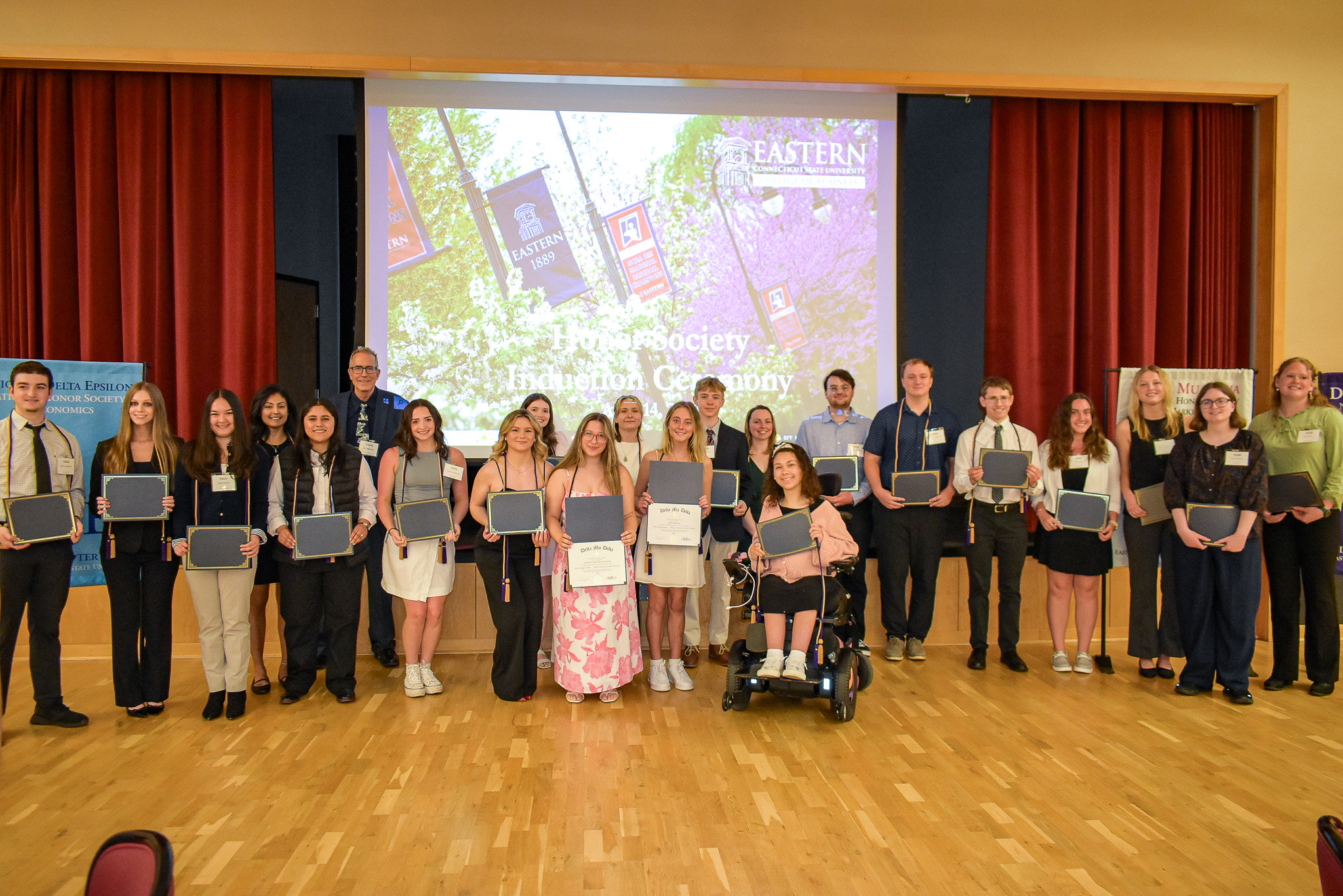 Students holding certificates at the Honor Society Induction Ceremony
