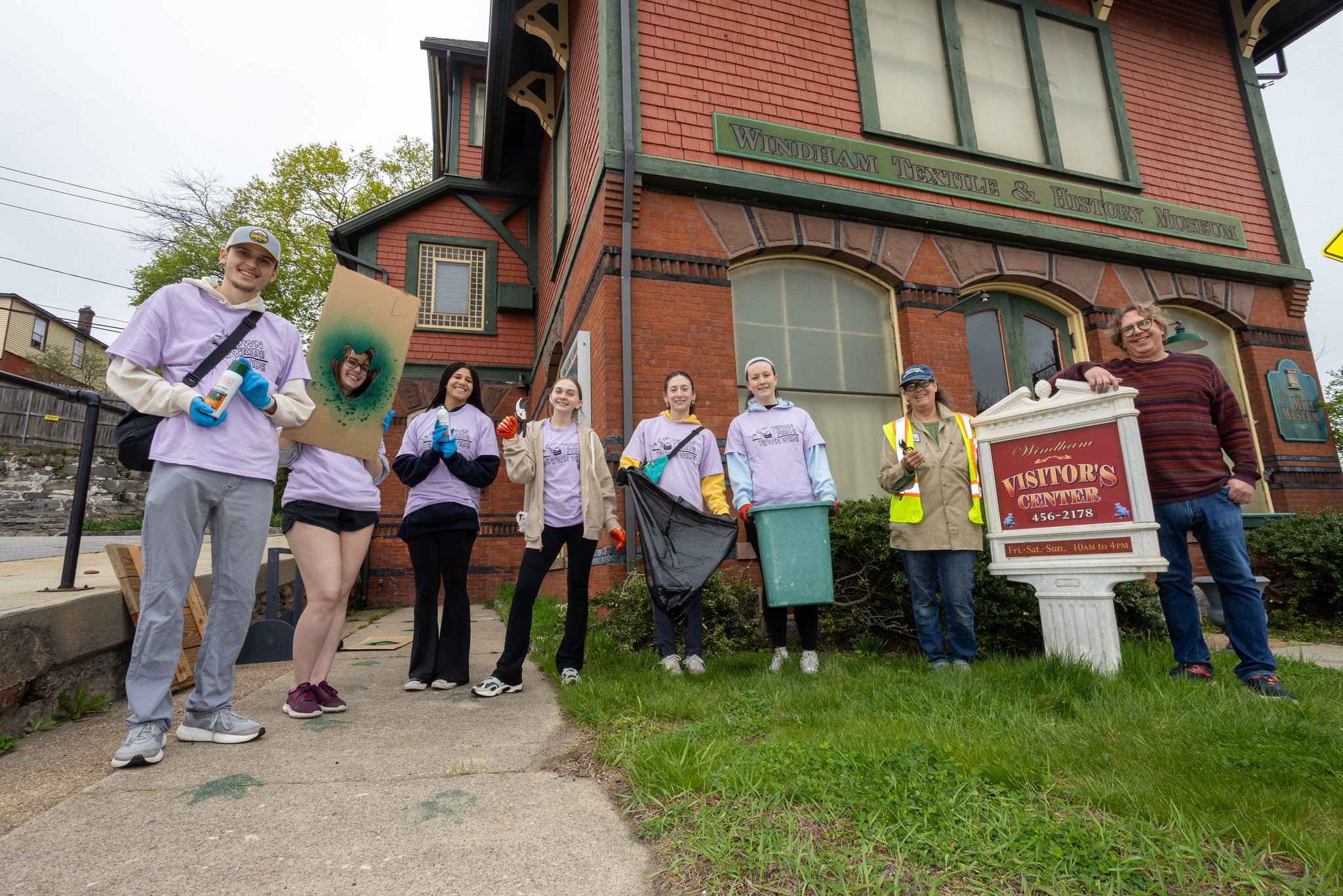 Student volunteers with cleanup supplies outside the Windham Textile and History Museum