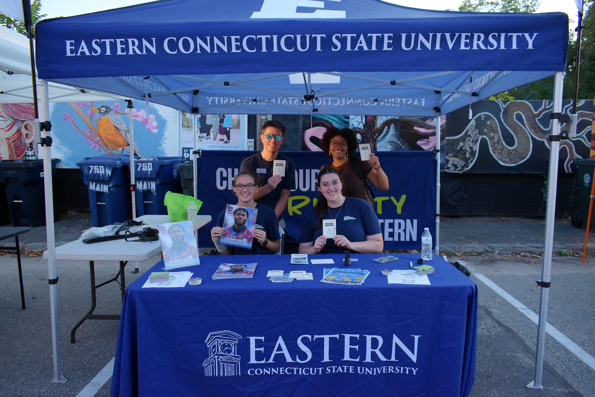 Students at an Eastern tent sharing Eastern Passport materials at a downtown event