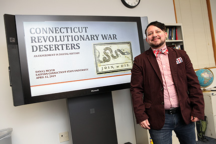 alumni standing in front of presentation