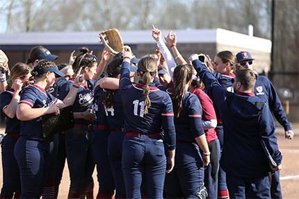 softball players cheering in a huddle