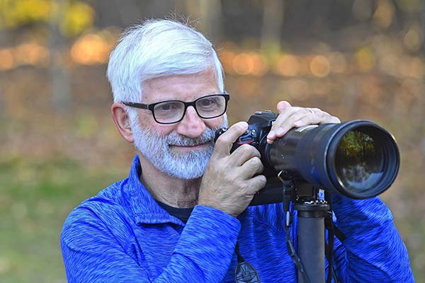 photojournalist John Shishmanian holding a camera