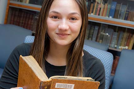 student Emily Barata reading a book