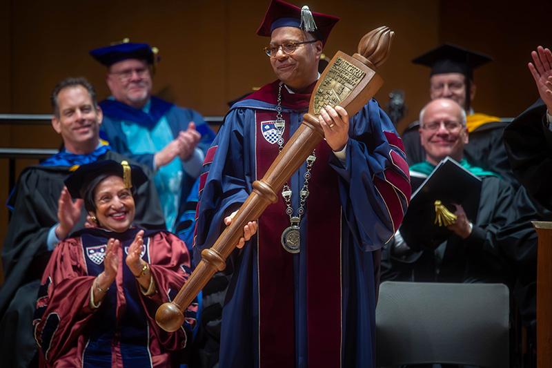 President Karim Ismaili wears the presidential medallion and holds the University's "mace" moments after being invested as Eastern's seventh president.