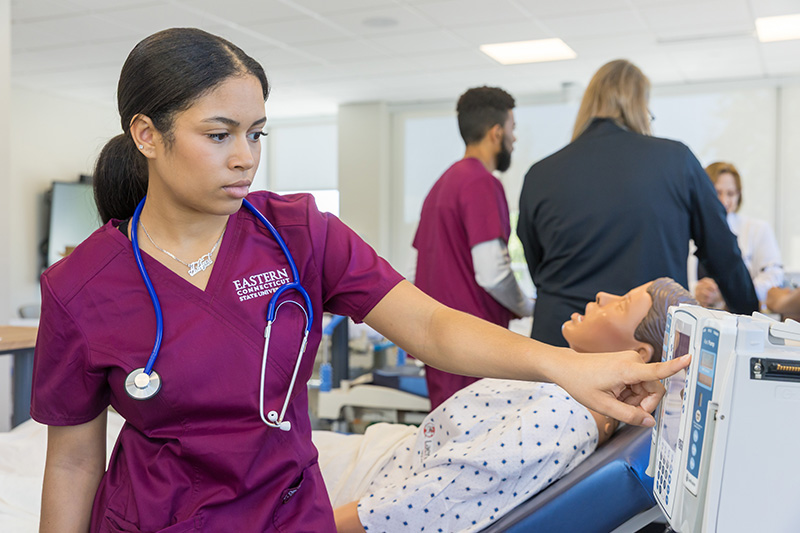 student nurse working with training dummy