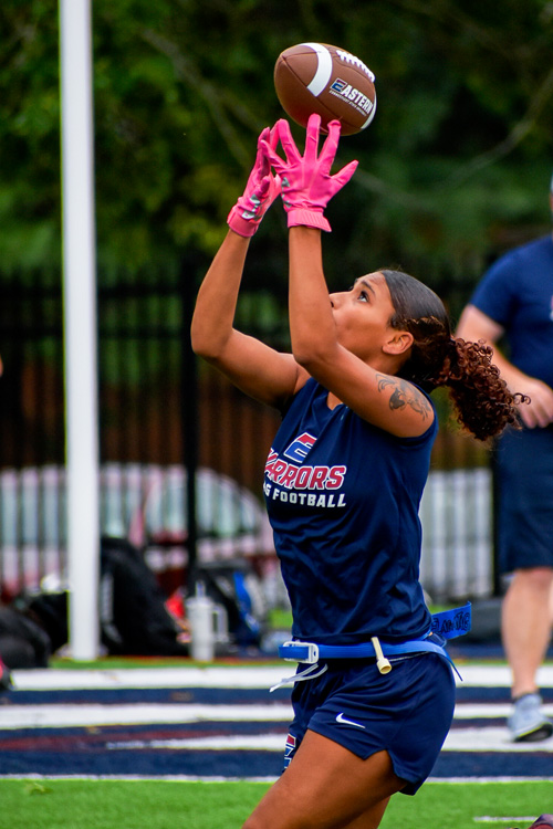 A team member catches a football during practice.