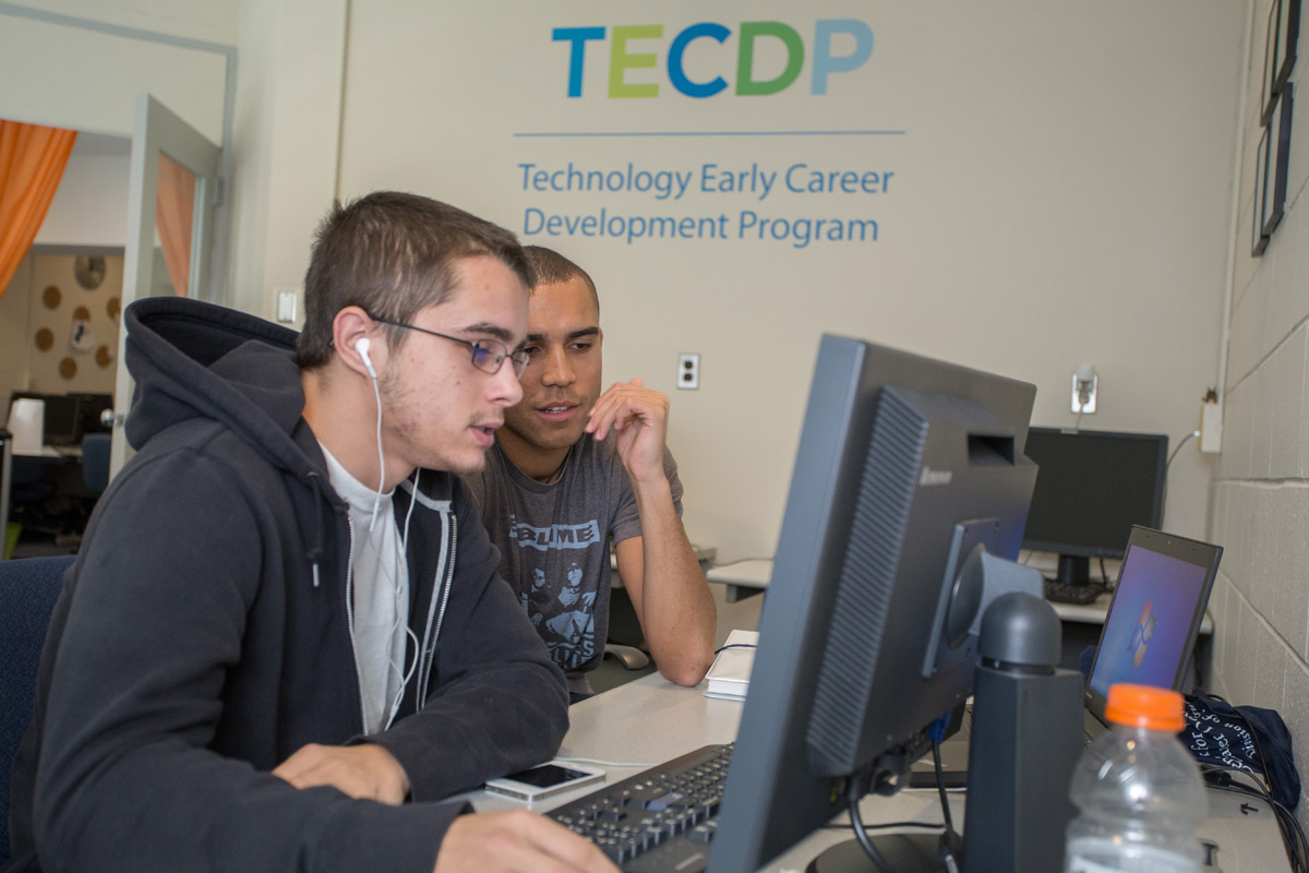 Student and staff member working at a computer