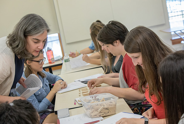 professor working with a class on the use of counting blocks in a classroom