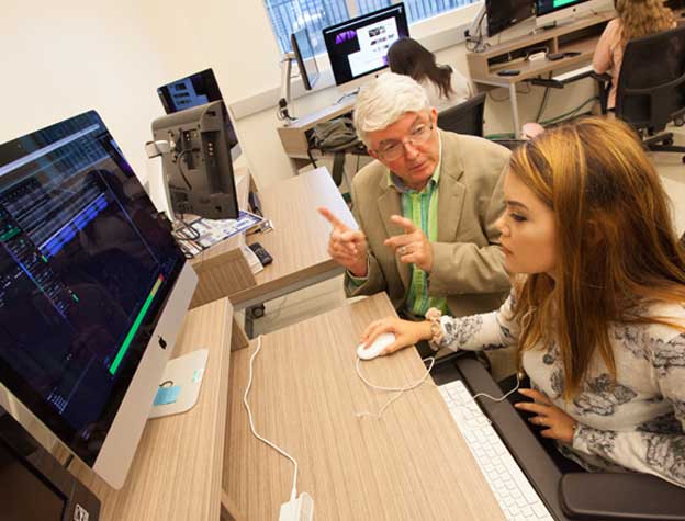 student in computer lab with professor