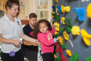 Education students supervise preschool children on the climbing wall of the Child and Family Development Resource Center (CFDRC)