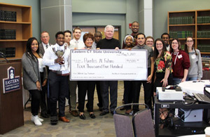 Residents of Occum Hall with the Warrior Cup trophy, alongside Rosie Hernandez, founder of Puentes al Futuro, and William Stover, director of Family and Community Partnerships (center, holding check)