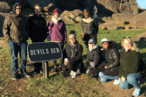 Students pose in front of the Devil's Den.