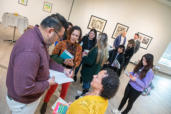  Cheng autographs copies of his book during a reception in the Art Gallery following his talk.