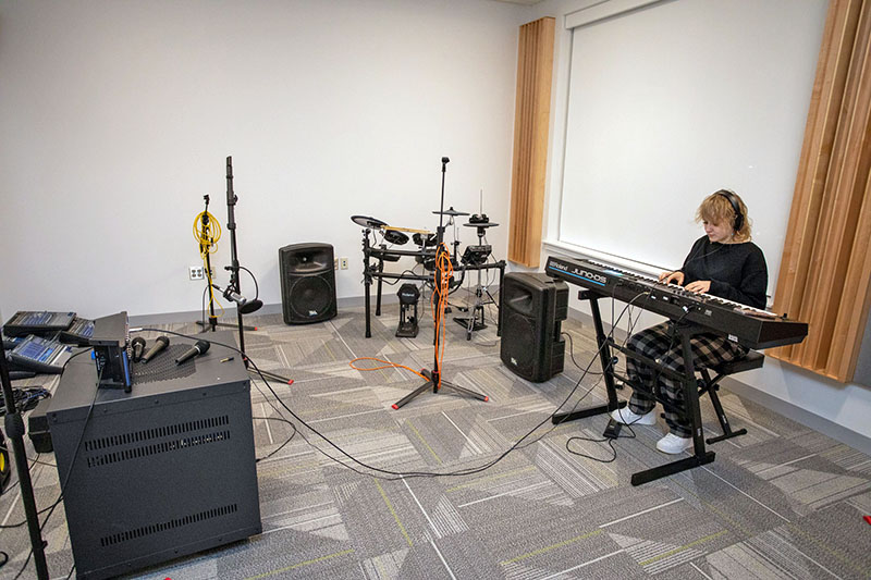 Student musician works in recording studio.
