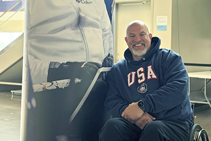 Steve Emt '03 in front of a banner of himself.
