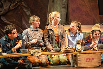 "The Burrow" cast having a meeting over dinner during the play.