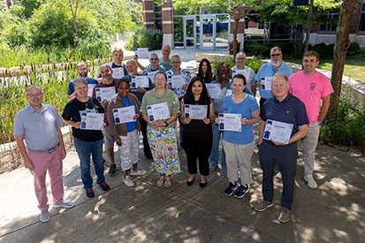 AI Summer Institute participants display their completion certificates in a group photo.