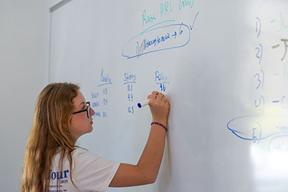 A student writes on a white board during "Resilience: The Science of Grit and Overcoming