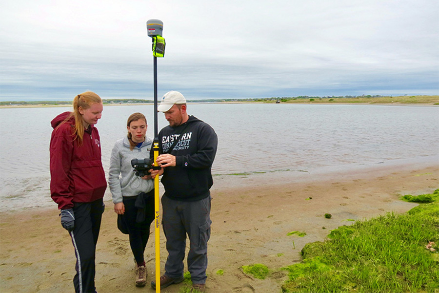 Oakley and former EES students measure seashore changes at Napatree Point during a previous research project on the Rhode Island coast. Photo credit: Janice Sassi, Watch Hill Conservancy.