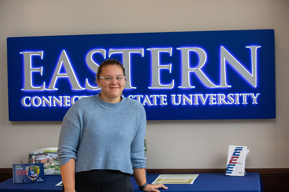 Maebel Haynes in front of Eastern Connecticut State University signage.