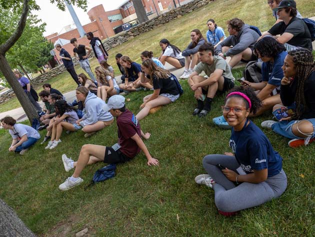 students sitting on the grass on campus