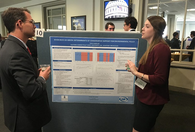 student explaining a graph to a man at a Washington DC conference