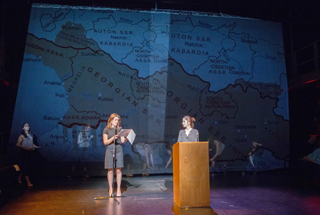 two students on stage with a map of the A.S.S.R. behind them on a screen