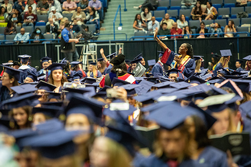 students in regalia sitting before commencement