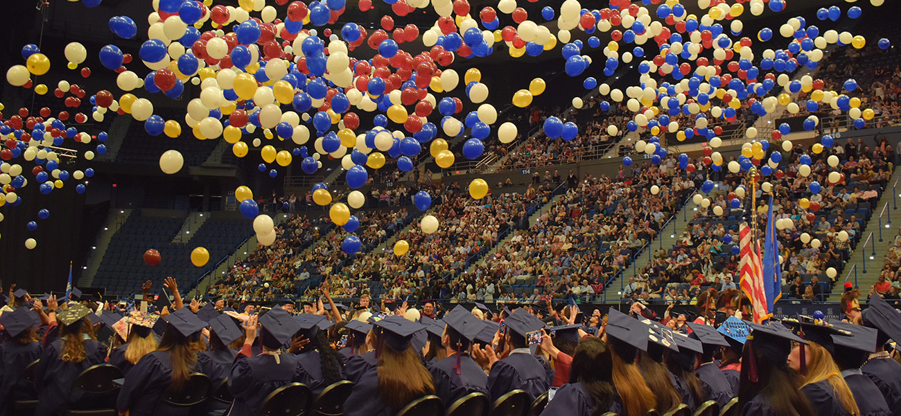 colorful balloons dropping from the ceiling at commencement