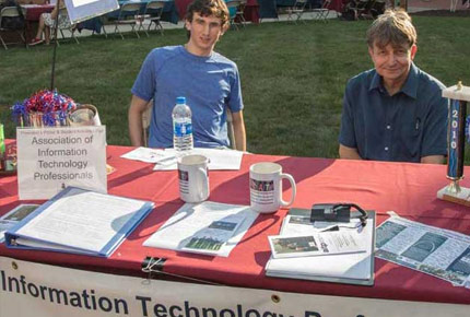 Student and professor sitting at table promoting AITP club
