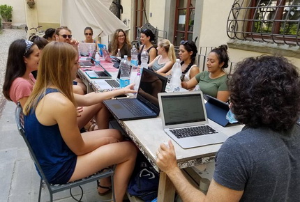 Students in Italy writing on laptops
