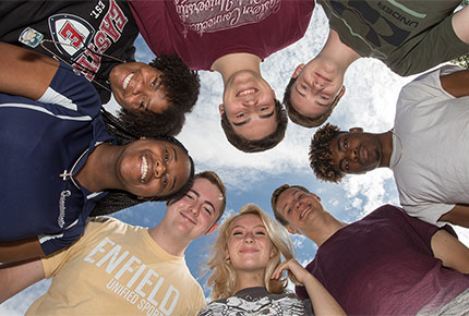 Students grouped around edges of photo looking down