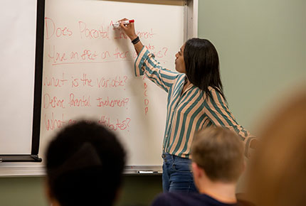 Professor writing on white board