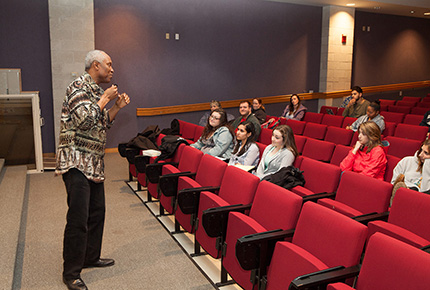 Professor addressing students in an auditorium