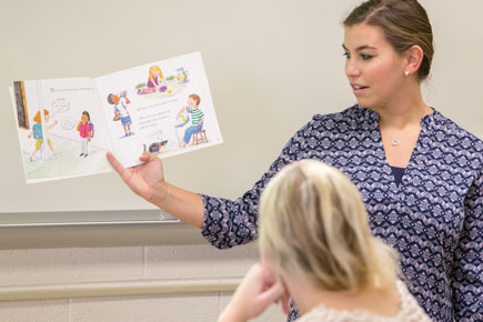 Teacher reading book to children