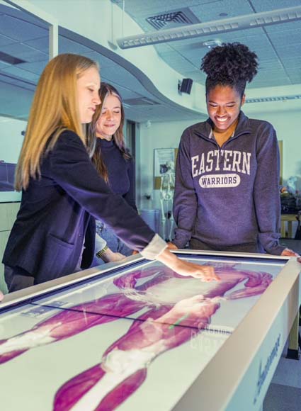 Professor and students using dissection table