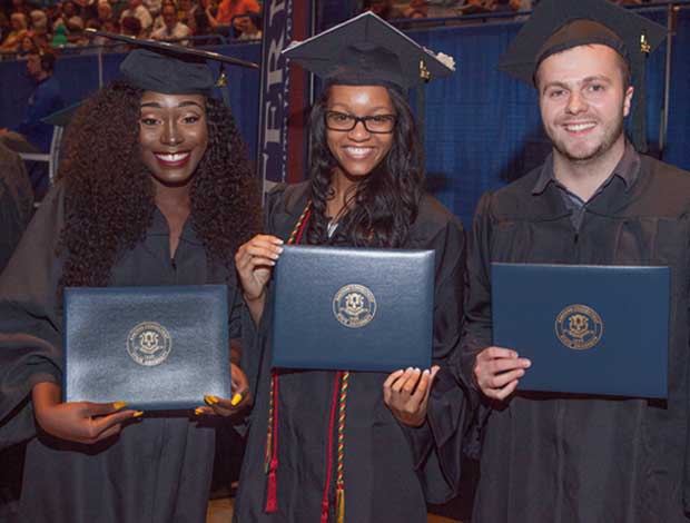 graduates holding diplomas