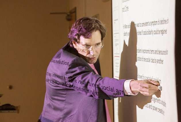 professor pointing at white board information