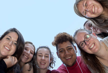 Students circled around looking down at the camera