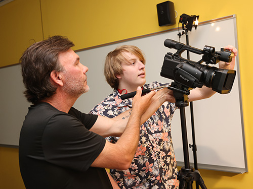 Brian Day and a student using a camera