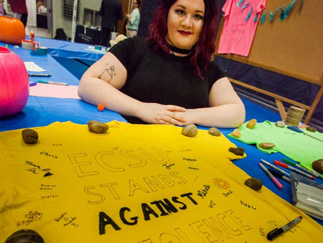 student with anti-violence poster
